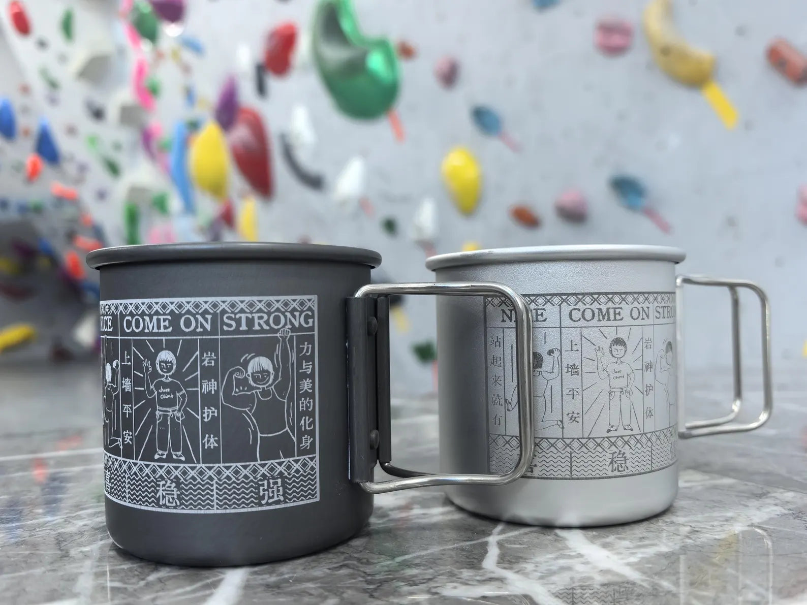 Two mugs with text and graphics on a textured surface with colorful background